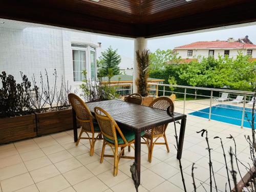 a table and chairs on a patio with a pool at Treekos Suite Hotel Istanbul Airport in Arnavutköy