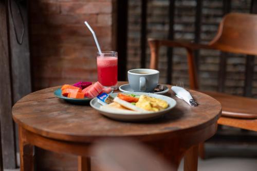 a table with two plates of food and a drink at The Kertha Ubud in Ubud