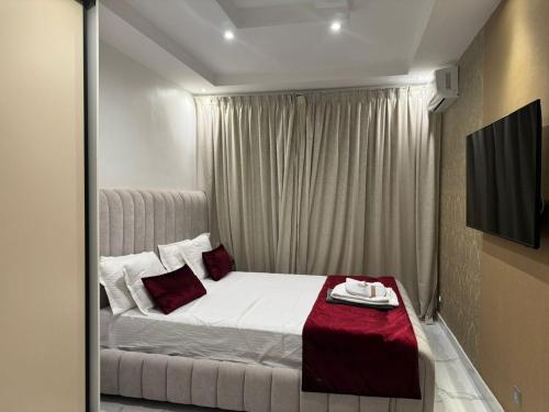 达喀尔Harmony residence dakar的卧室里有一张白色的床和红色的枕头