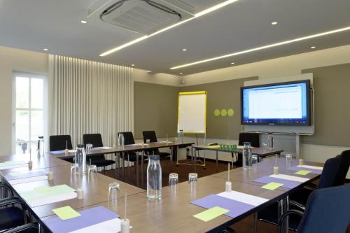 a conference room with tables and chairs and a projection screen at Mintrops Land Hotel Burgaltendorf in Essen
