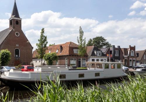 two boats are docked in front of a church at Het Waterhotel in Heerenveen