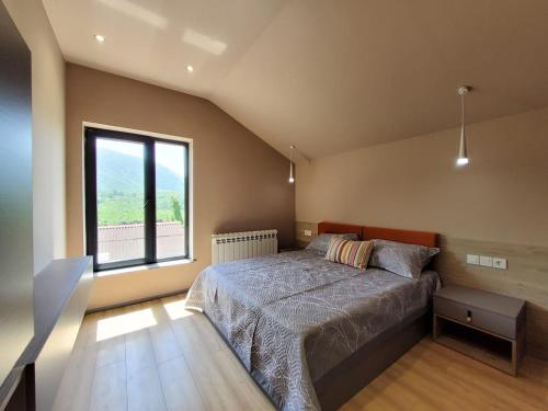 a bedroom with a bed and a large window at lady and bear villa in İsmayıllı