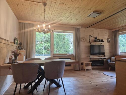 a dining room with a table and chairs and a television at Chaletwohnung Innerkrems in Innerkrems