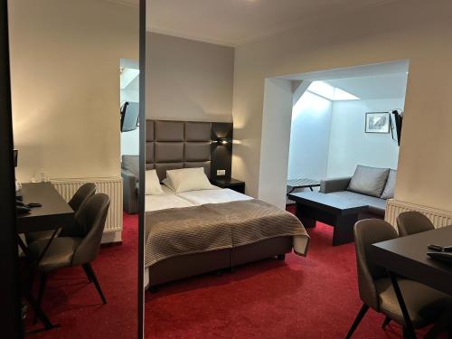 una camera da letto con un letto e uno specchio di REST HOTEL VARIA Działdowo a Działdowo