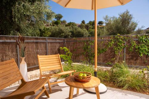 a patio with two chairs and an umbrella and a table at Cloud Nine Villa in Évyiros
