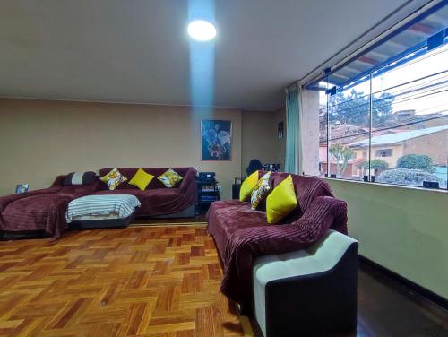 a living room with a couch and a bed at Dpto Amplio, TV75in, Cochera, Céntrico y BBQ in Huancayo