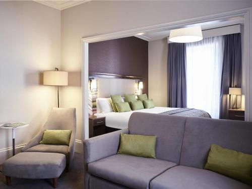 a hotel room with a bed and a couch at Mercure Exeter Southgate Hotel in Exeter