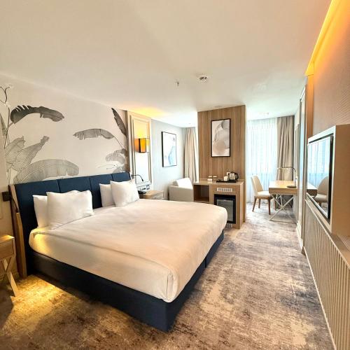 a hotel room with a large bed and a desk at Sia Hotel Thermal & Spa in Nilüfer