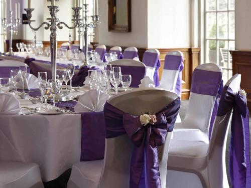 a set of tables with purple and white chairs at Mercure Exeter Southgate Hotel in Exeter