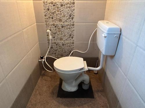 e bagno con servizi igienici bianchi e doccia. di The Pepper Room a Chikmagalūr