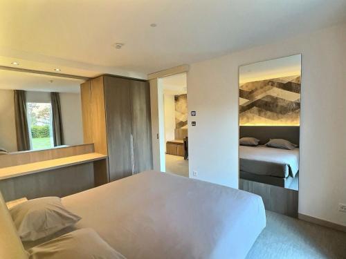 a bedroom with a white bed and a mirror at Attica Résidences, Lausanne in Saint-Sulpice