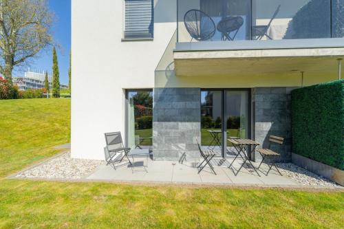 a patio with chairs and a table in front of a house at Attica Résidences, Lausanne in Saint-Sulpice