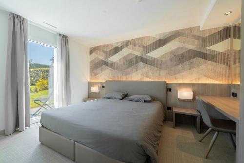 a bedroom with a bed and a desk and a window at Attica Résidences, Lausanne in Saint-Sulpice