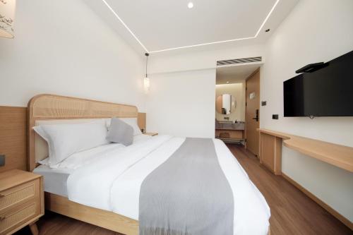 a bedroom with a large bed and a flat screen tv at Huazhu Junyu Valley 