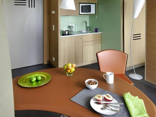 a dining room table with a plate of fruit on it at Aparthotel Adagio Bordeaux Centre Gambetta in Bordeaux