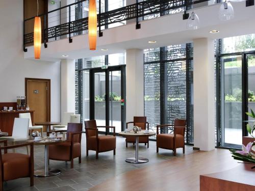 a restaurant with tables and chairs and windows at Aparthotel Adagio Bordeaux Centre Gambetta in Bordeaux