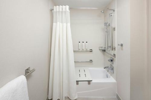 a bathroom with a white shower curtain and a sink at Fairfield by Marriott Mission Viejo Orange County in Mission Viejo