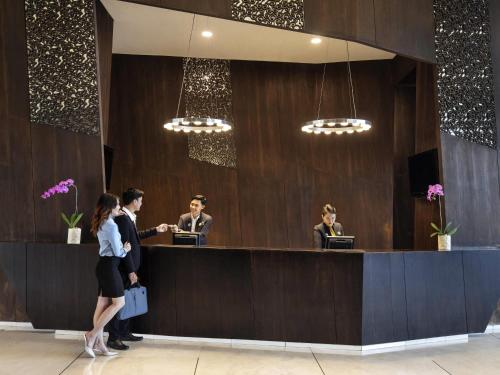 a group of people standing at a reception desk at Novotel Lampung in Bandar Lampung