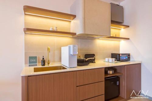 a kitchen with a sink and a white refrigerator at 22 Macalisterz by ALV in George Town