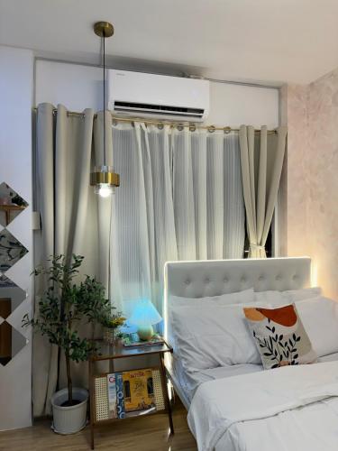 a bedroom with a white bed and a window at Casa Issabella Cozy & Stylish Studio in Sorsogon in Sipak