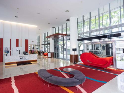 a lobby with a red chair and a glass table at Ibis Singapore on Bencoolen - Newly Renovated in Singapore