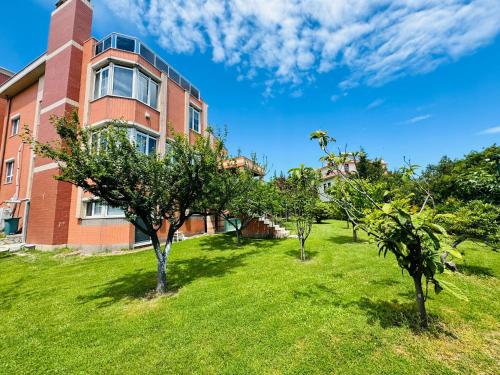 an apartment building with trees in front of it at Treekos Suite Hotel Istanbul Airport in Arnavutköy