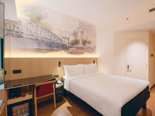 a hotel room with a bed and a painting on the wall at Ibis Singapore on Bencoolen - Newly Renovated in Singapore