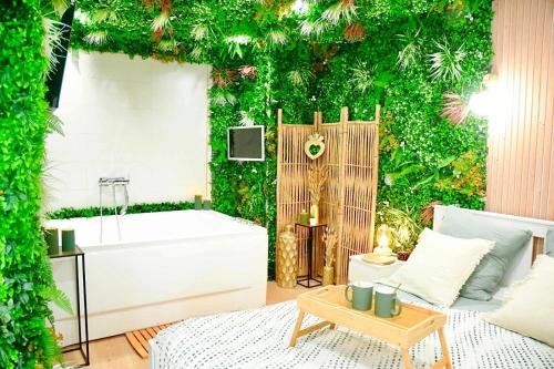 a bathroom with a green wall with a bath tub at La Boétie, Cocon Central, Double Balneo Bathtub in Bordeaux