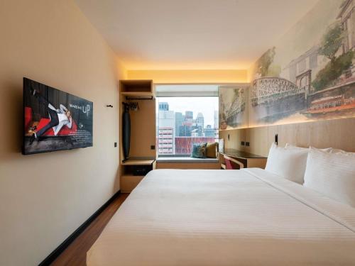 a bedroom with a large white bed and a window at Ibis Singapore on Bencoolen - Newly Renovated in Singapore