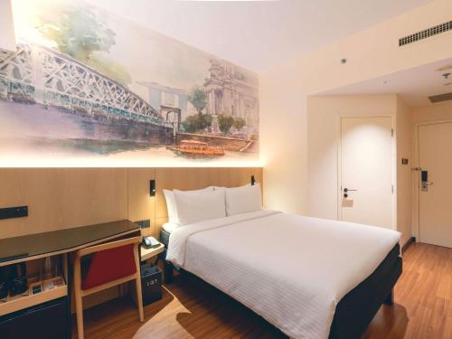 a hotel room with a bed and a painting on the wall at Ibis Singapore on Bencoolen - Newly Renovated in Singapore