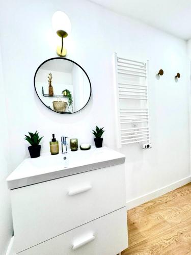 a bathroom with a white vanity and a mirror at La Boétie, Cocon Central, Double Balneo Bathtub in Bordeaux