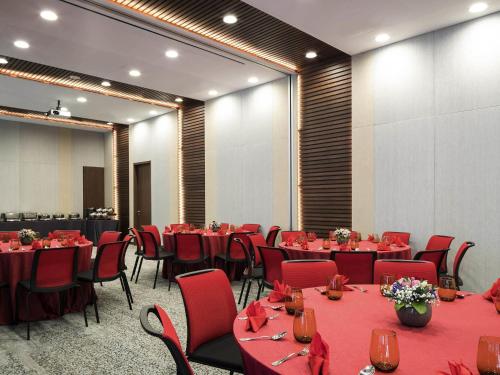 a conference room with tables and chairs with red table cloth at Ibis Singapore on Bencoolen - Newly Renovated in Singapore