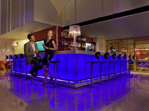 a man and a woman sitting at a bar at Ibis Singapore on Bencoolen - Newly Renovated in Singapore