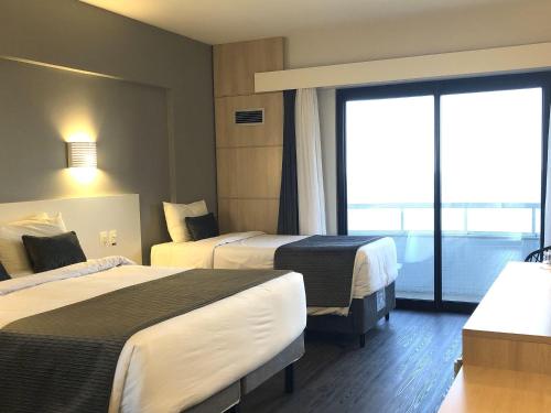 Ein Bett oder Betten in einem Zimmer der Unterkunft Mercure Camboriu