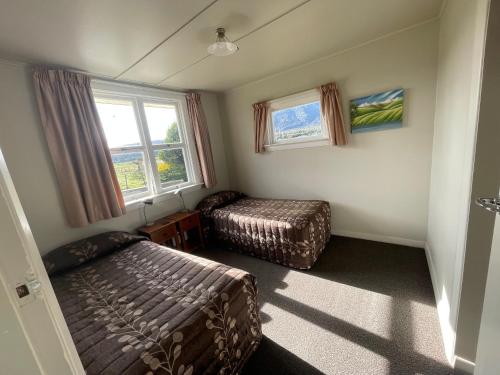 a bedroom with a bed and a bed and a window at Glacier View Motel in Tatare