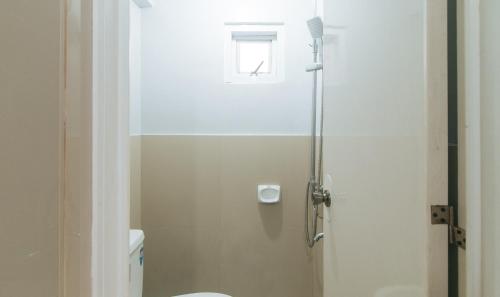 a bathroom with a shower with a toilet and a window at V-Cloud Hills Boarding House Near NAIA Terminal in Manila