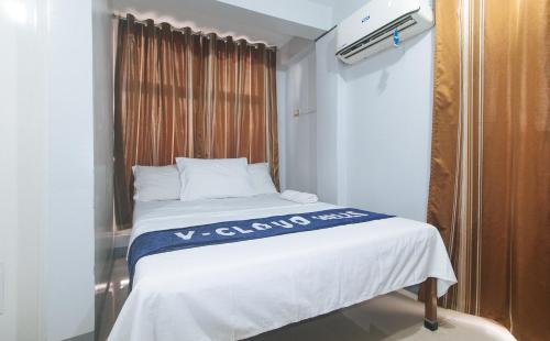 a bed in a small room with a window at V-Cloud Hills Boarding House Near NAIA Terminal in Manila