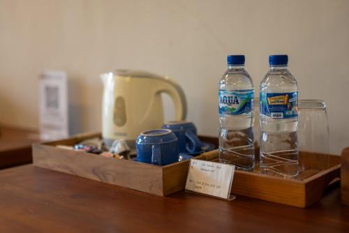 two bottles of water sitting on top of a table at The Kertha Ubud in Ubud