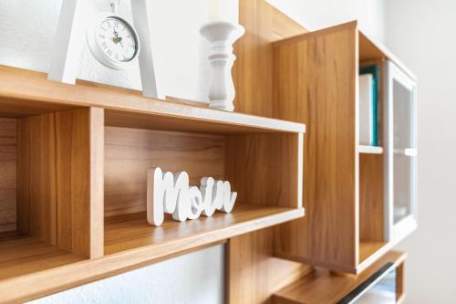 a wooden book shelf with a clock on it at Ferienwohnung Muschelbank No 4 in Büsum
