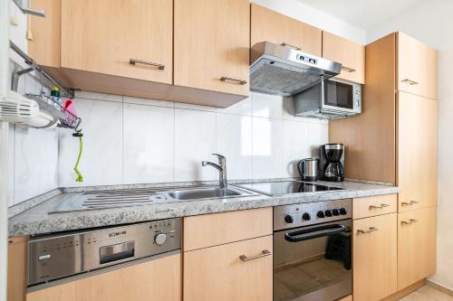 a kitchen with a sink and a stove at Ferienwohnung Muschelbank No 4 in Büsum