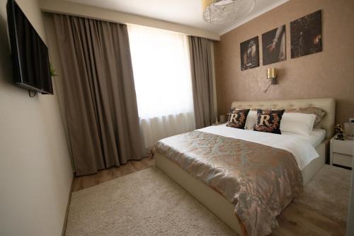 a bedroom with a bed and a large window at The Royal House 102 sqm 2BR Two Floor Apartment in Hunedoara