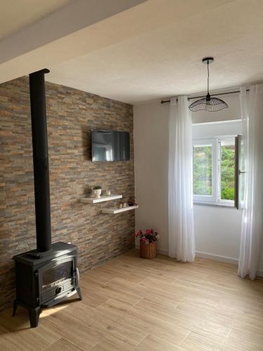 a living room with a brick wall and a stove at Casa da Ribeirinha in Sertã