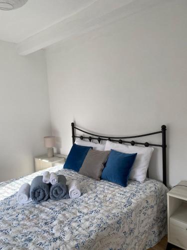 a bed with blue pillows and towels on it at Casa da Ribeirinha in Sertã