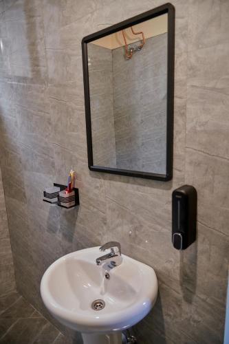 a bathroom with a sink and a mirror on the wall at Samora River Lodge in Arusha