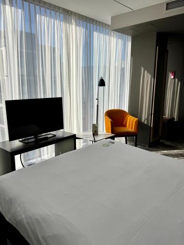 a hotel room with a bed and a tv and a chair at ibis Styles Warszawa City in Warsaw