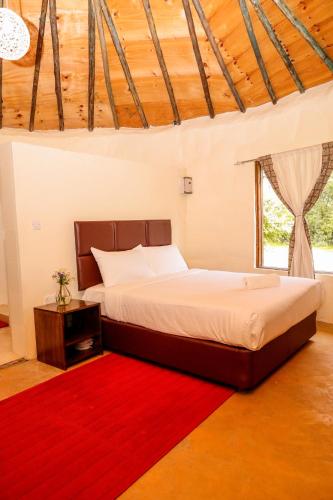 a bedroom with a bed and a red rug at Kikopey Beach Camp Lake Elementaita in Gilgil