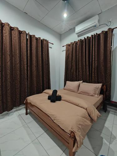 a bedroom with a bed with a black headboard at Sakan Moslim only, 4 airconds, wifi in Alor Setar