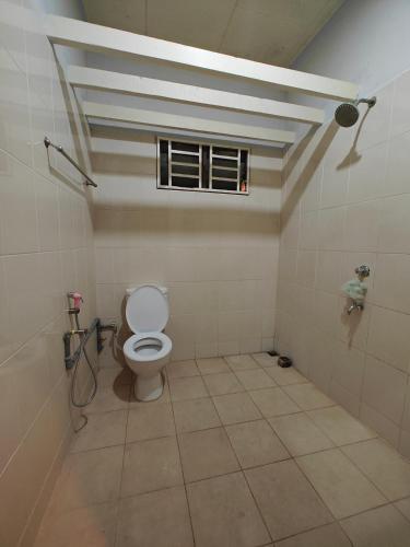 a bathroom with a toilet and a window at Sakan Moslim only, 4 airconds, wifi in Alor Setar