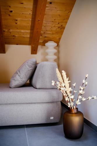 a living room with a couch and a vase with flowers at Sky Room Square View - Bernina Experience in Tirano