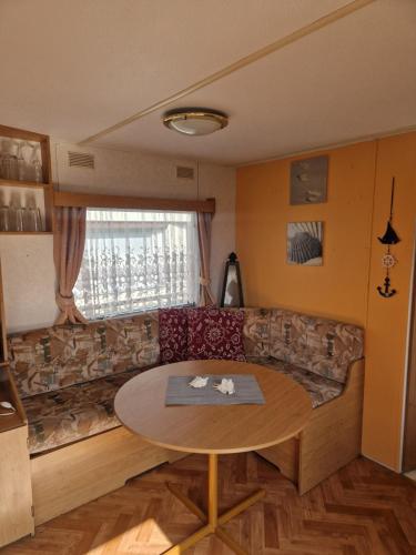 a living room with a couch and a table at Bungalow am Hafen in Gager